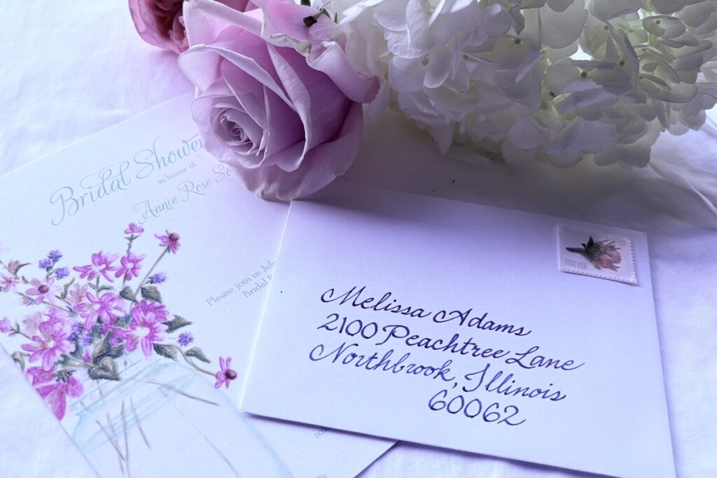 purple flowers and an envelope lettered in a fountain pen